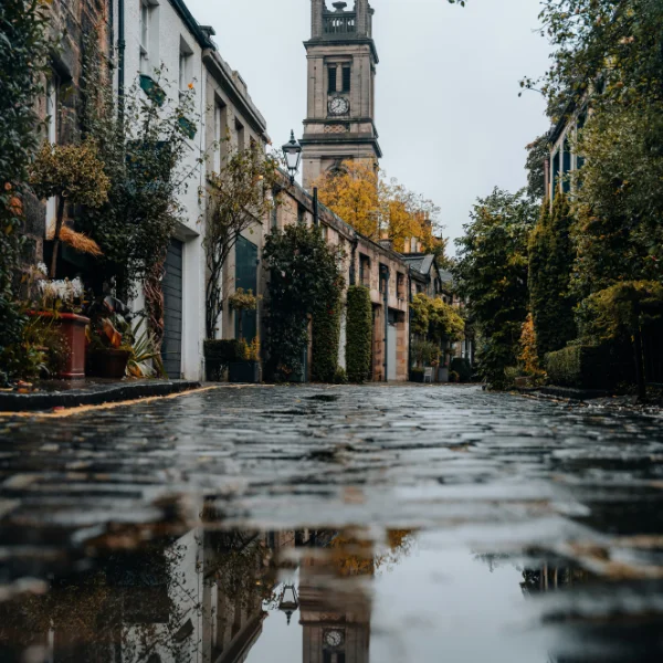 Birminghams cobblestone street with autumn reflections and moody charm.