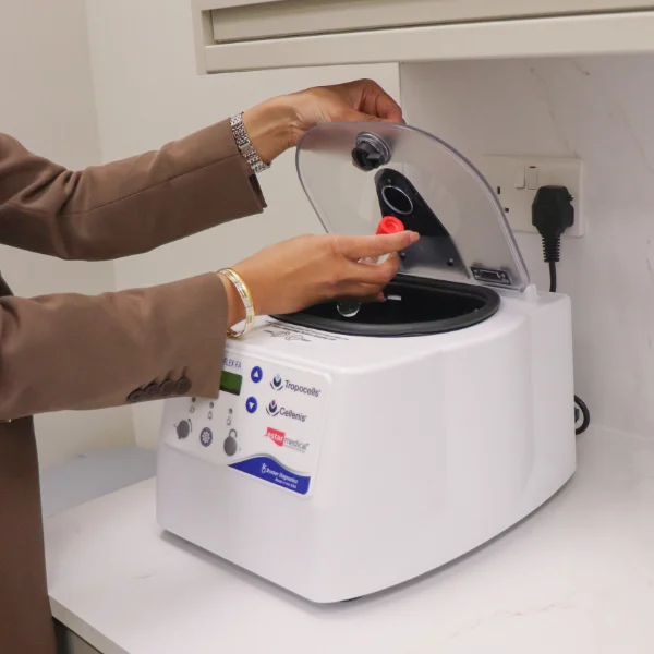 Practitioner placing extracted blood into a centrifuge